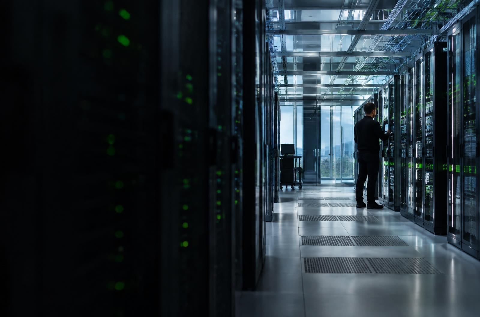 Engineer working among network equipment in a modern data centre